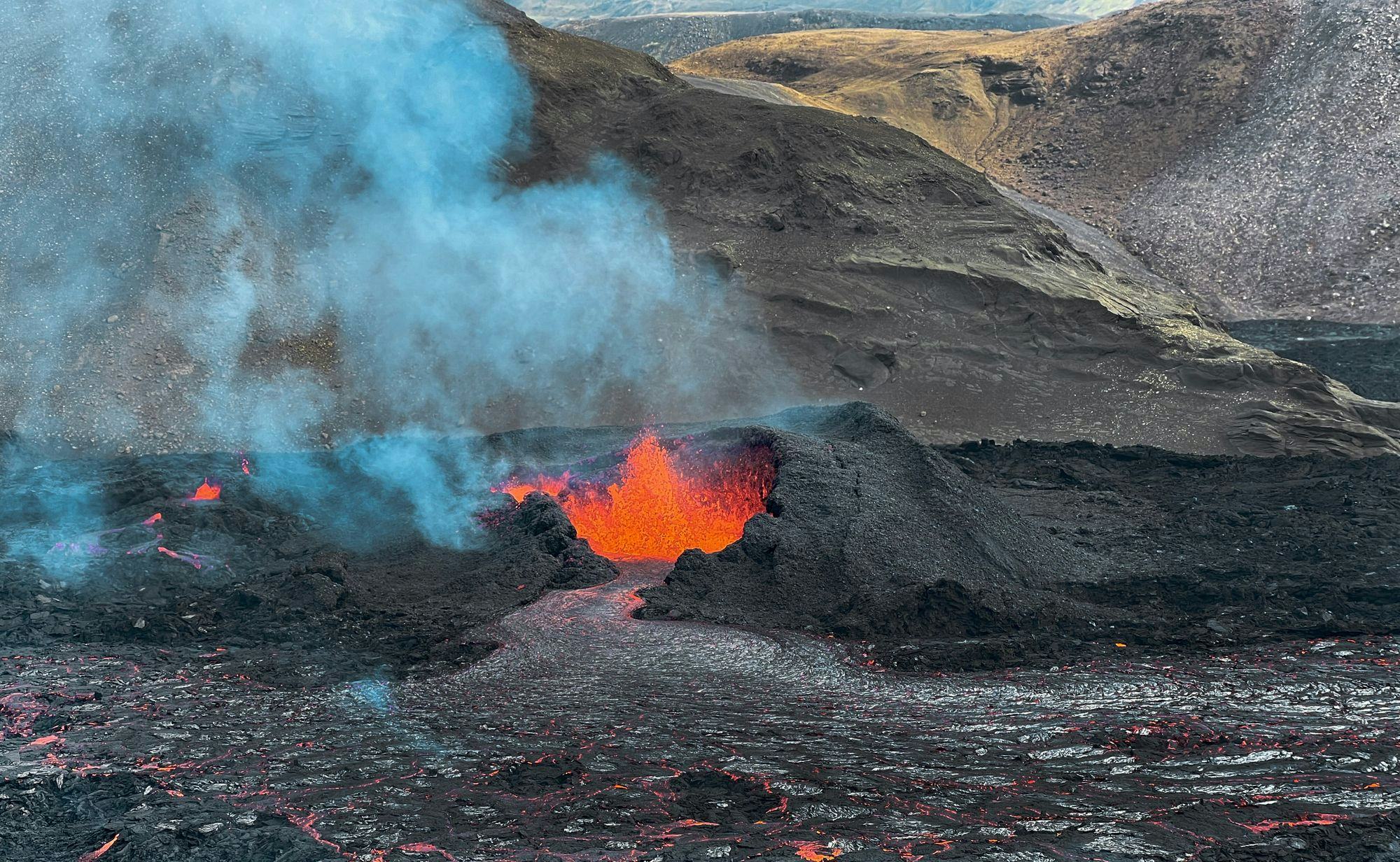 Lava erupting and flowing from a volcano crater