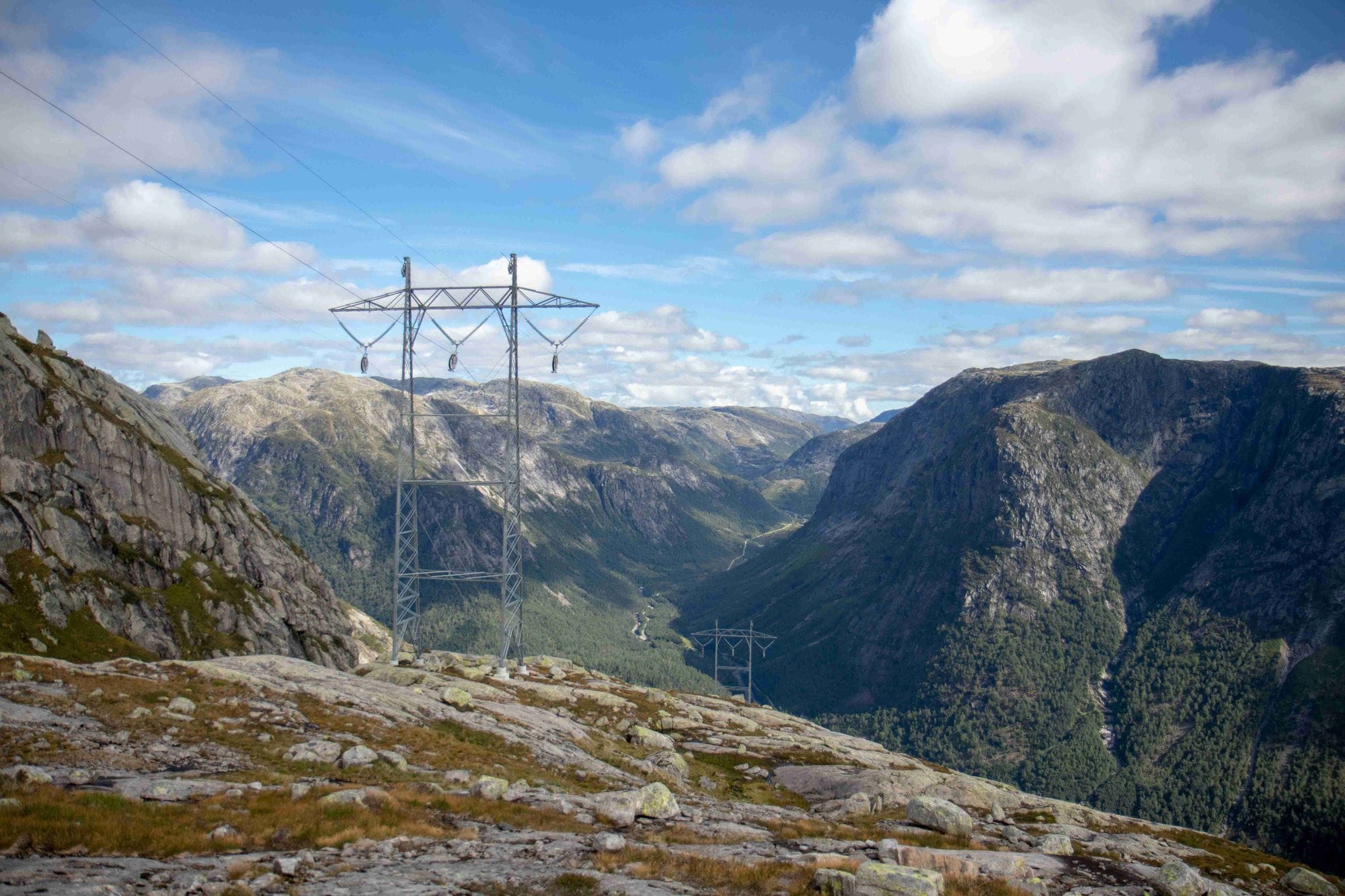 A mast on top of a mountain, a blue sky with a few clouds