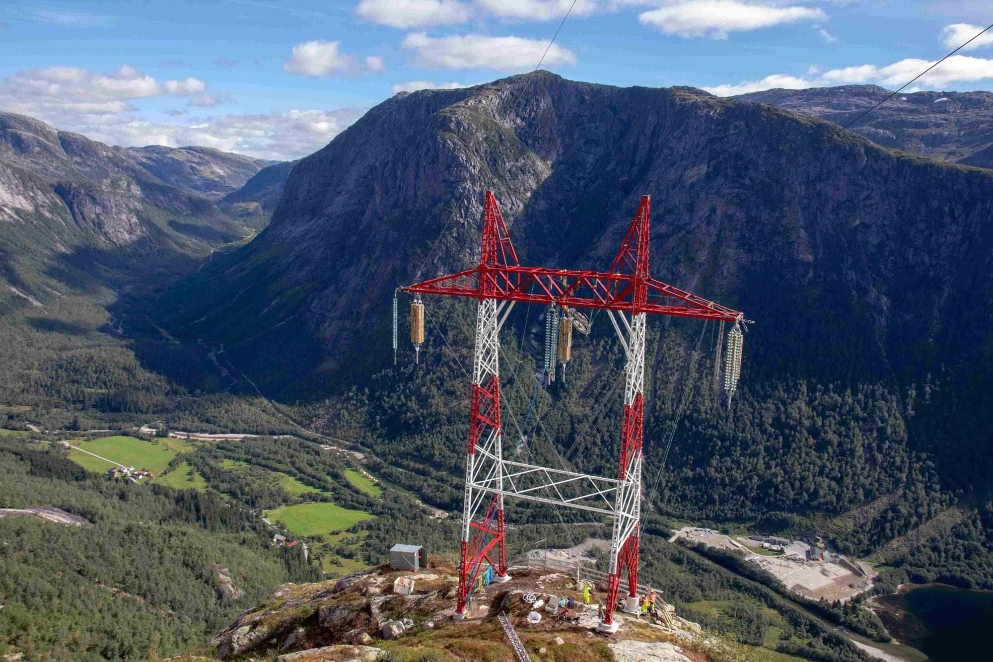 Red and white mast with mountains in the background and blue sky