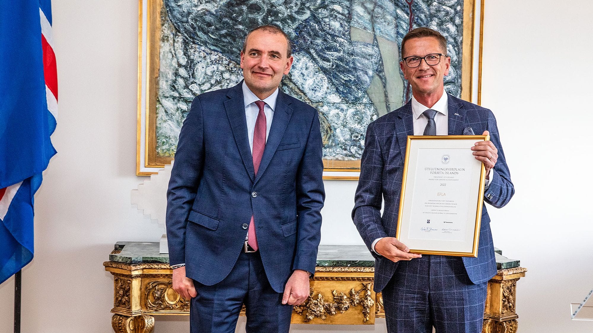 EFLA official standing next to the President holding export achievement award in his hands