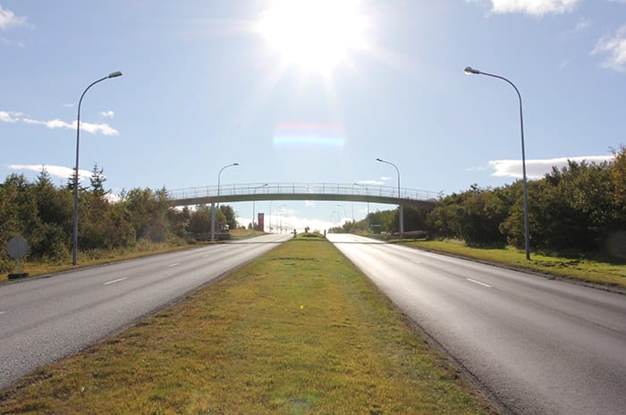 Sun shinning bright at a pedestrian bridge which is centrally located at the picture