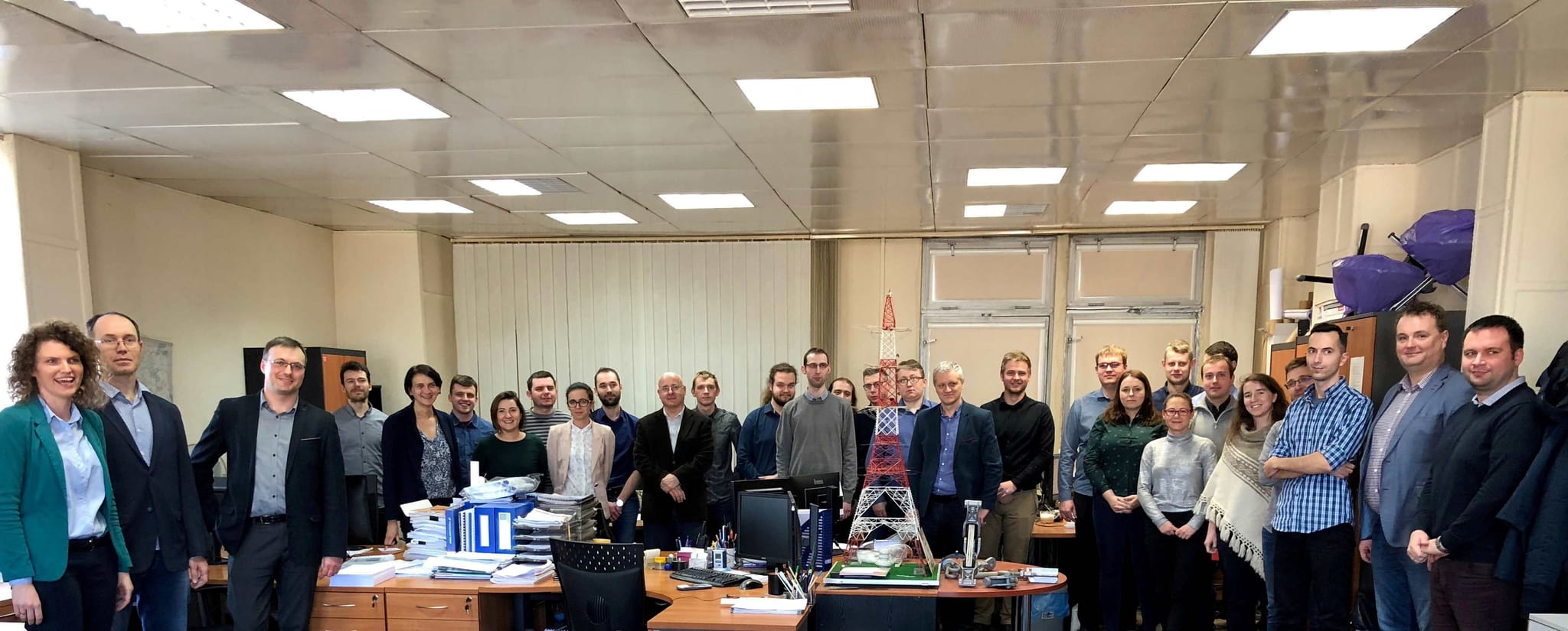 Photo of 30 people lined up in a row in an office room