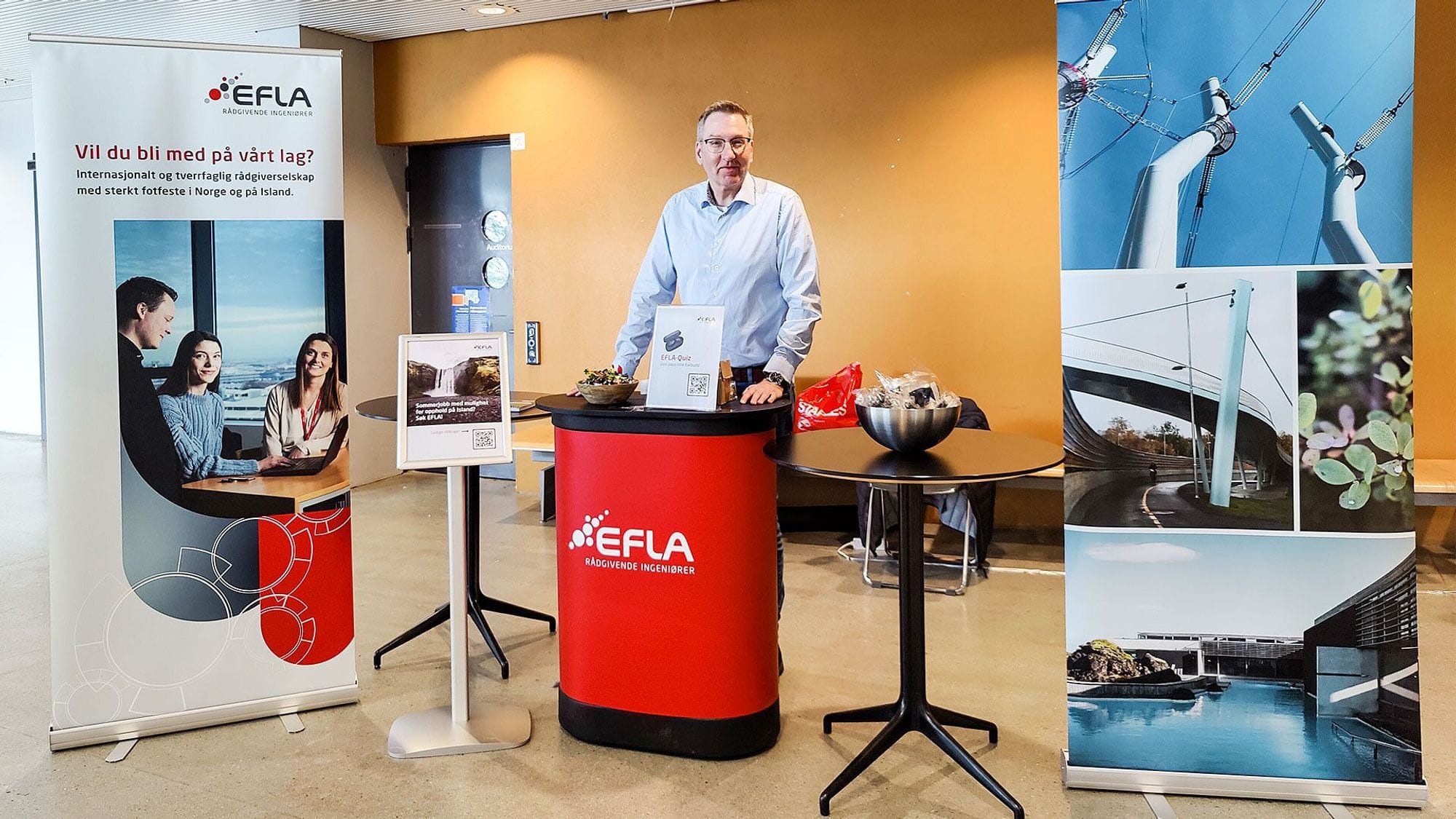 A man with glasses standing in an EFLA booth