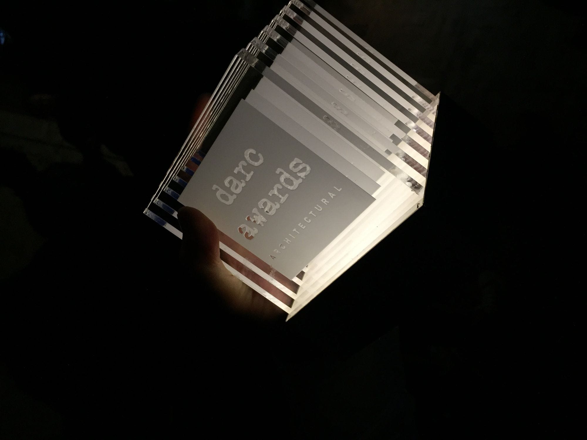 Cube formed transparent Trohphy branded with darc award in a black surrounding, the trophy is it with a white light
