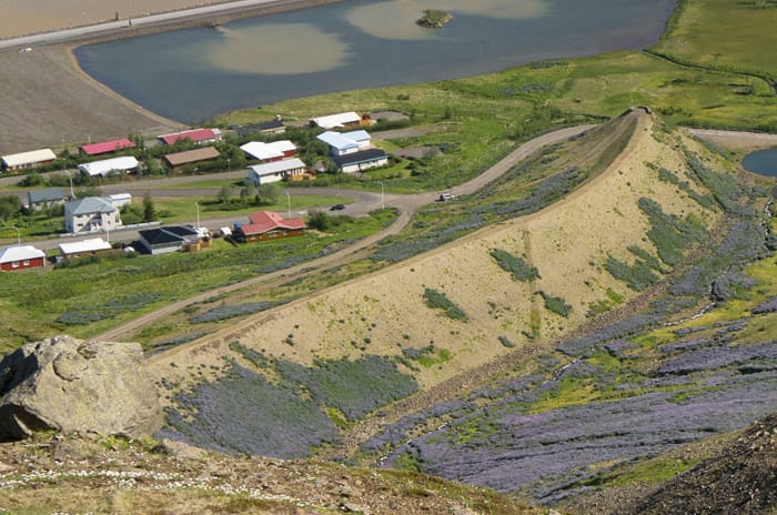 3D picture of a valley with few houses on the left