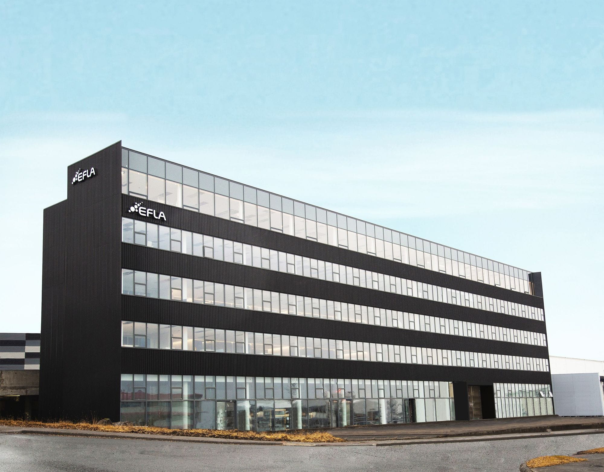 Black office building with glass windows and the EFLA logo on the front and side. Blue sky above, street running along the building.