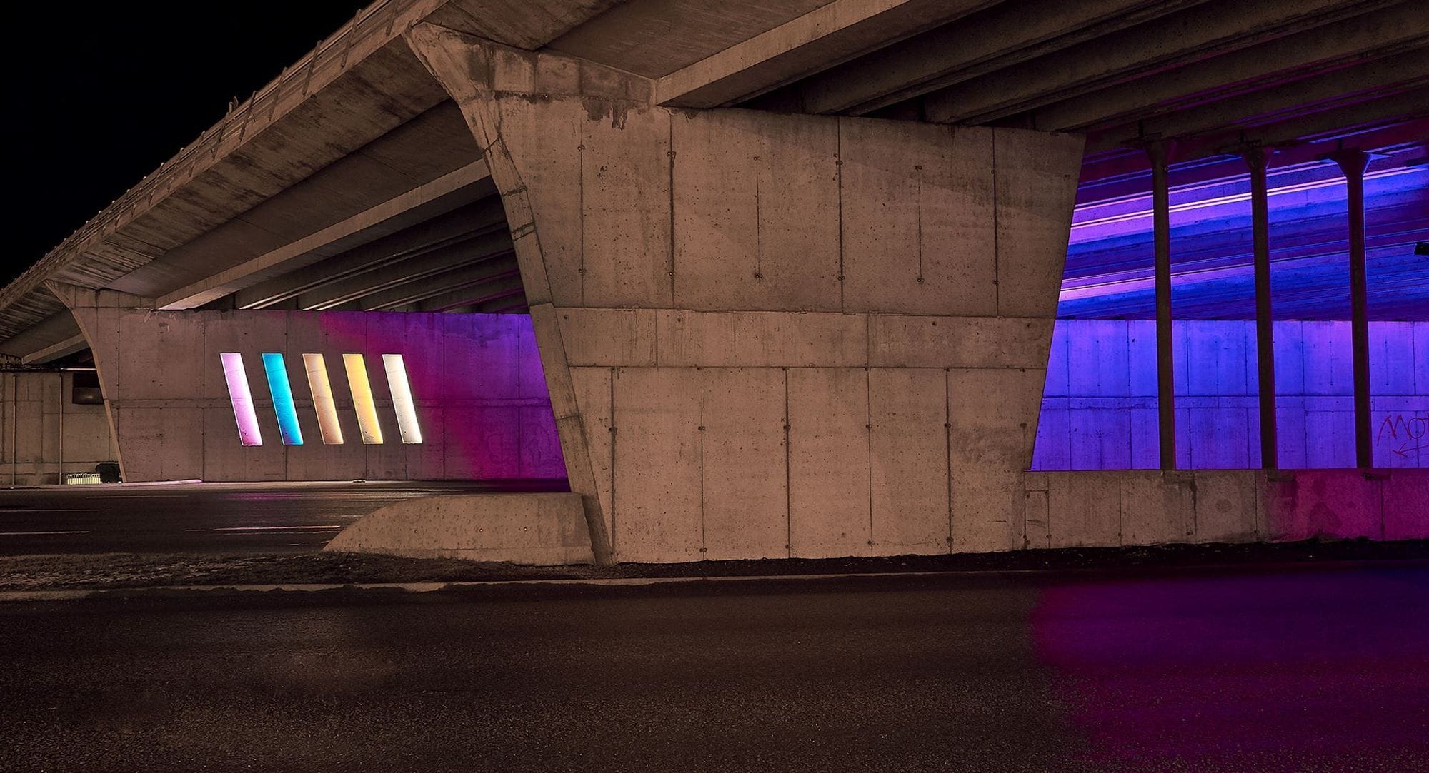 multicolour lightning design under a bridge in the back of a concrete wall