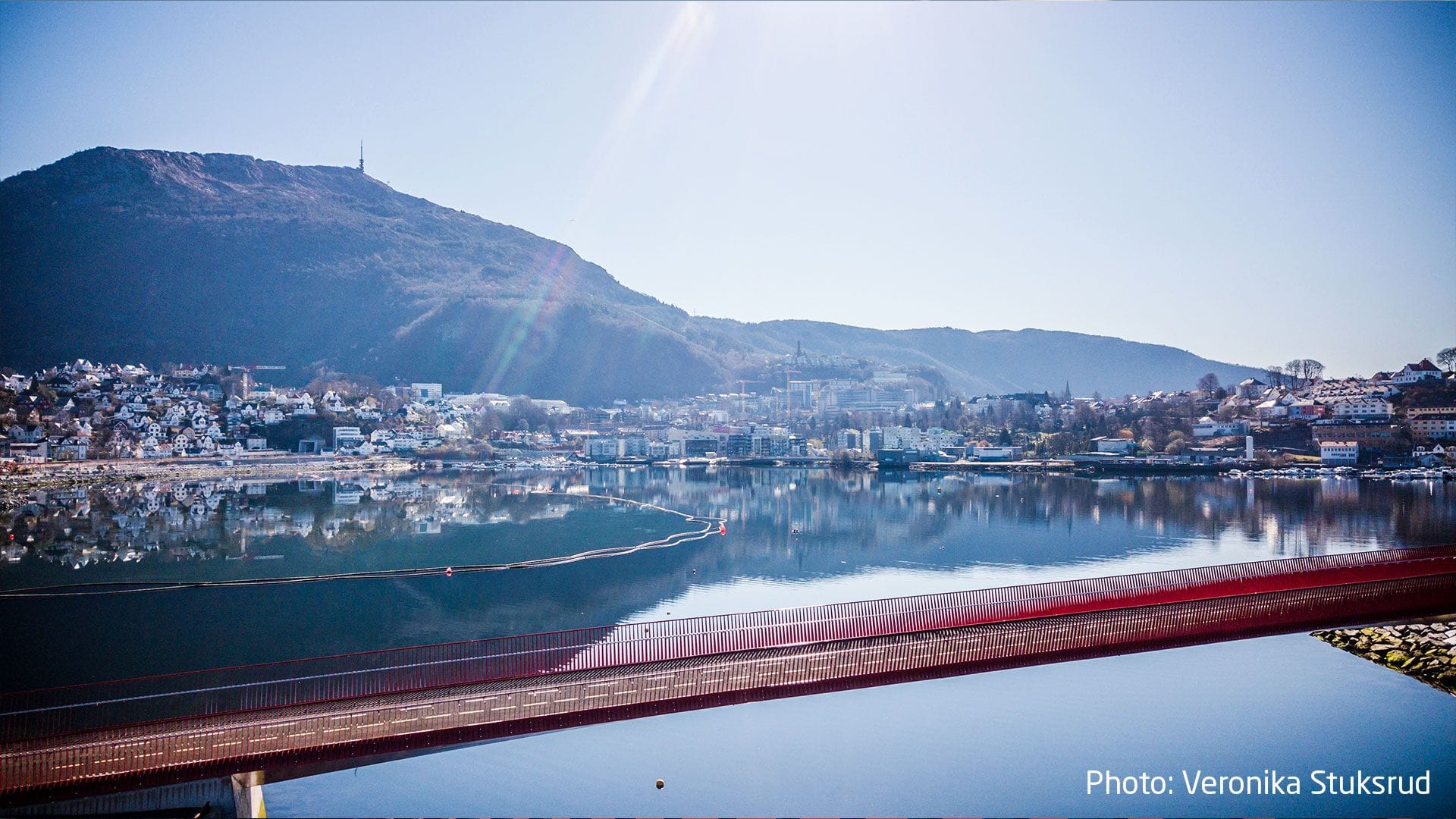 Red bridge and a town in the background on a sunny day