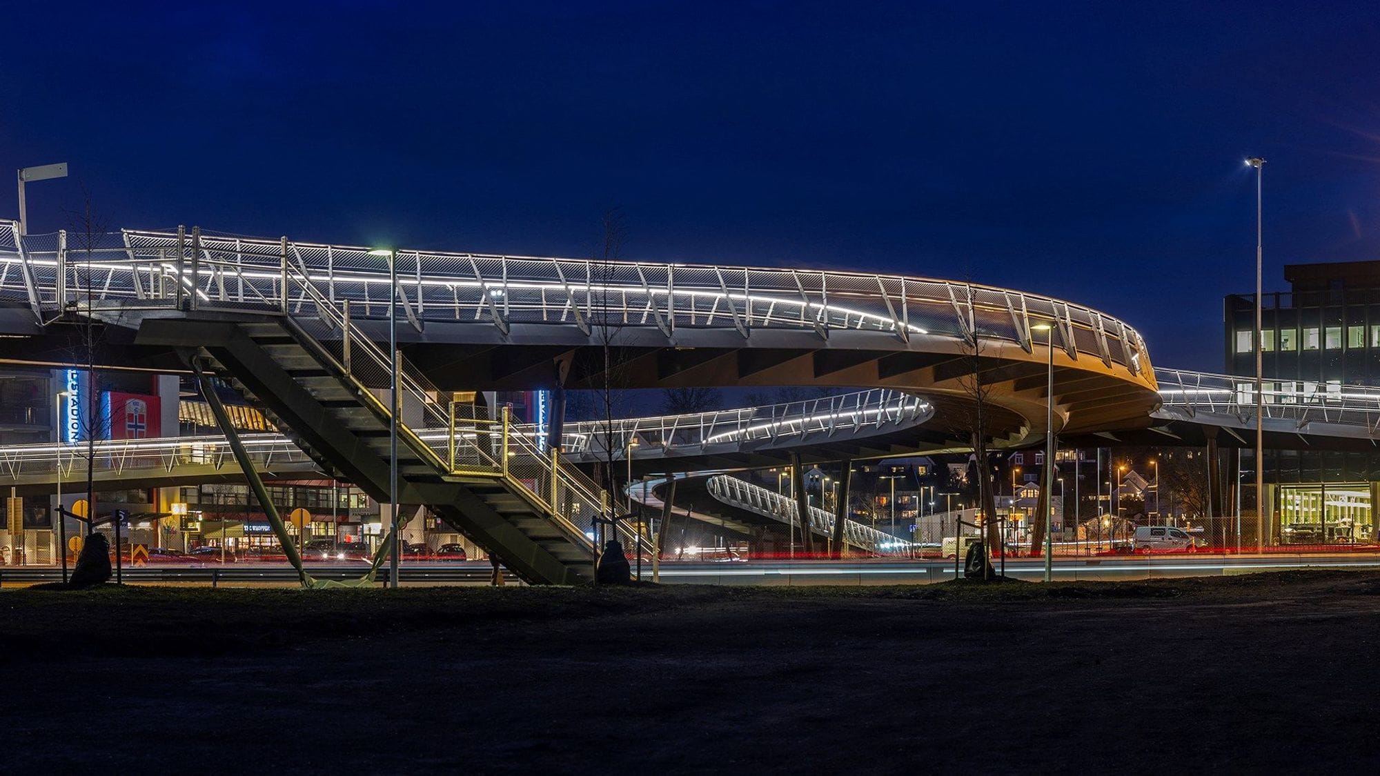Footbridge in a dark environment. The lighting of the bridge's railing shows the shape of the bridge in a dark environment. 