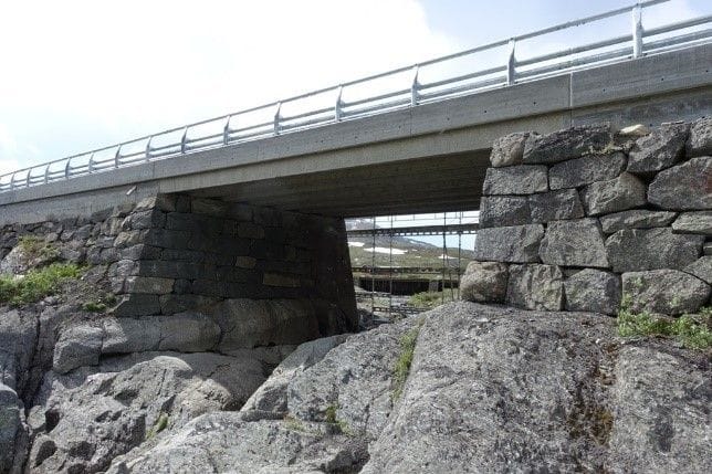 Newly constructed bridge with new steel railings on the edge and needly loaded stone posts.