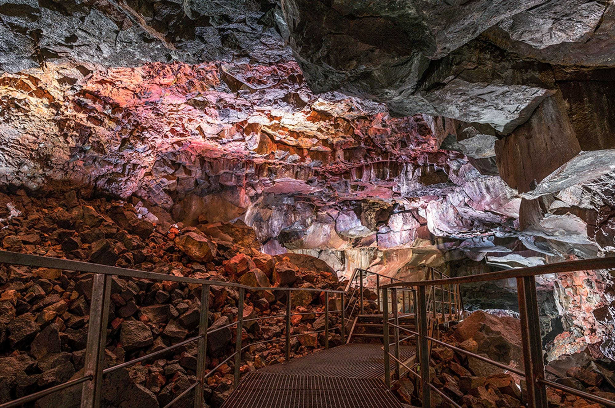 Interior of a red stone cave with metal stairs