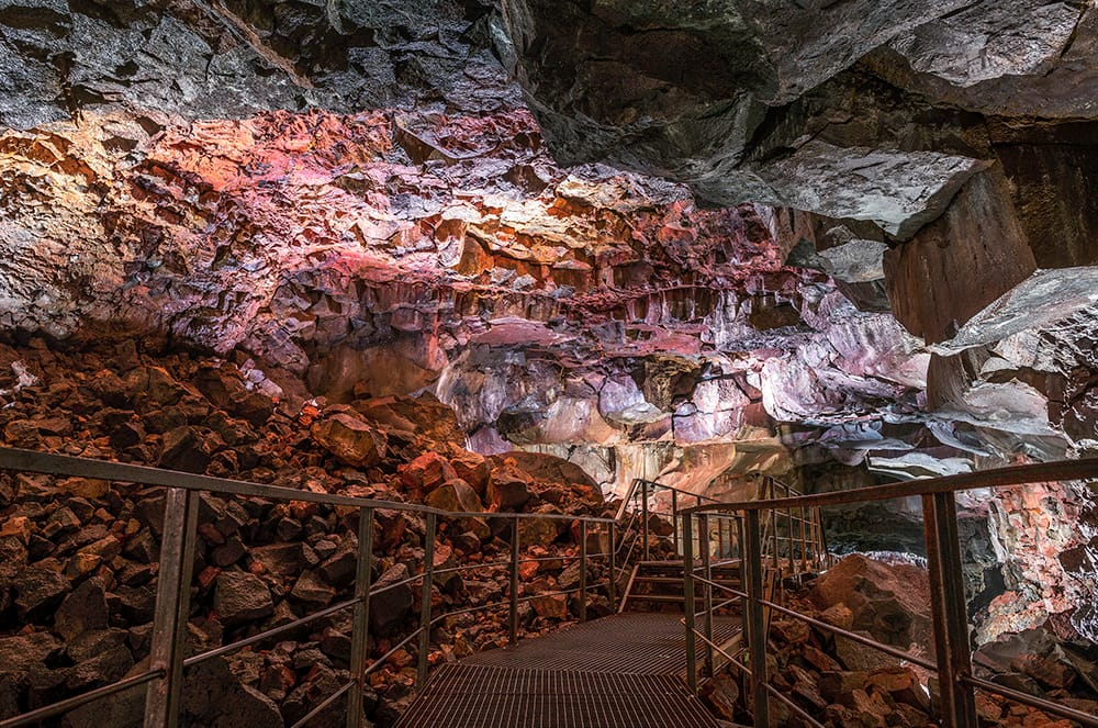 Interior of a red stone cave with metal stairs