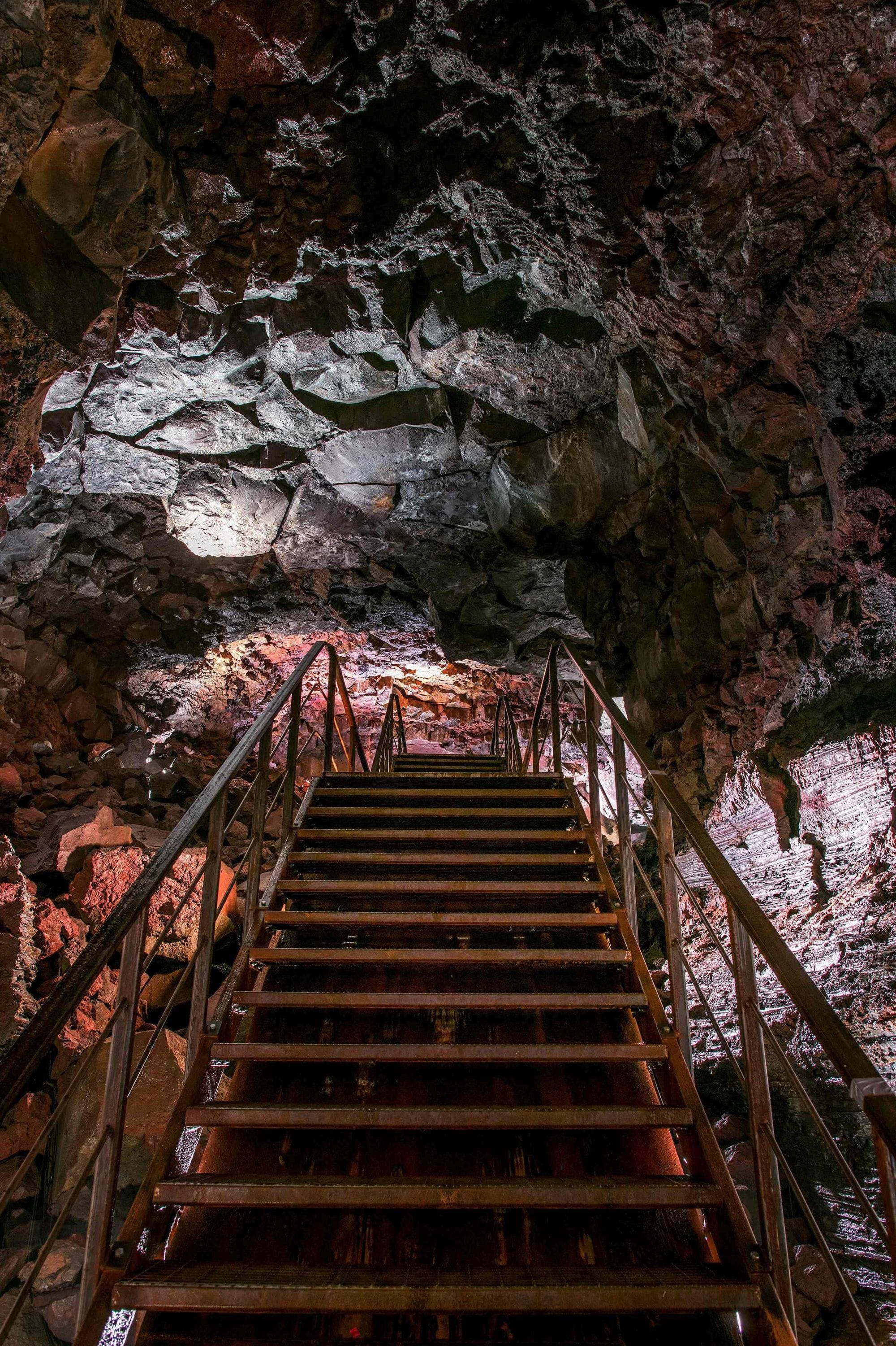 Inside a red, purple and green cave with stairs in the middle
