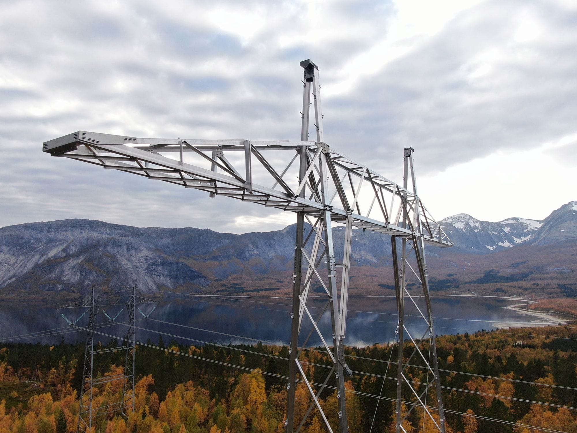 Big transmission tower next to a beautiful serene lake