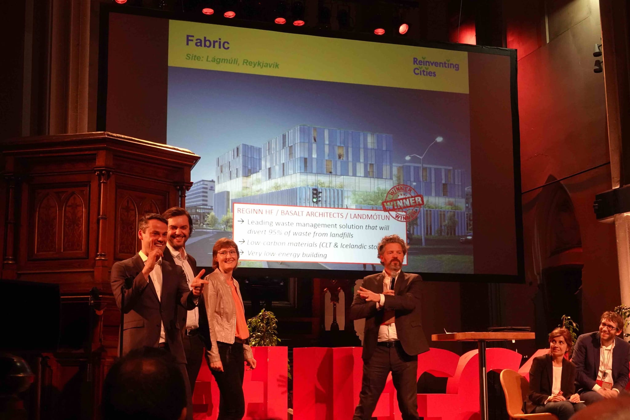 Design team of Living landscape standing in a hall and receiving the prize