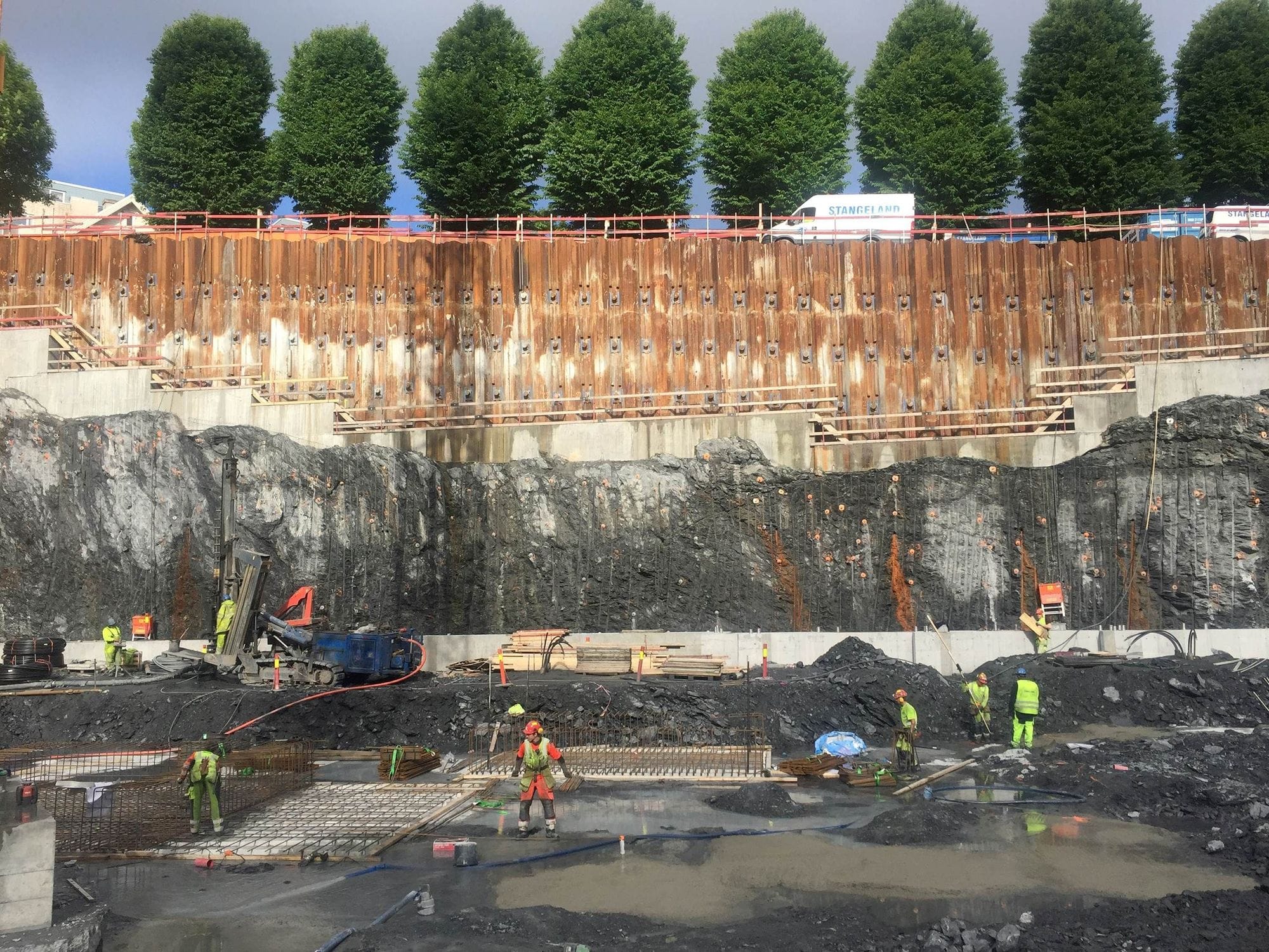 People in yellow work clothes working on a construction site