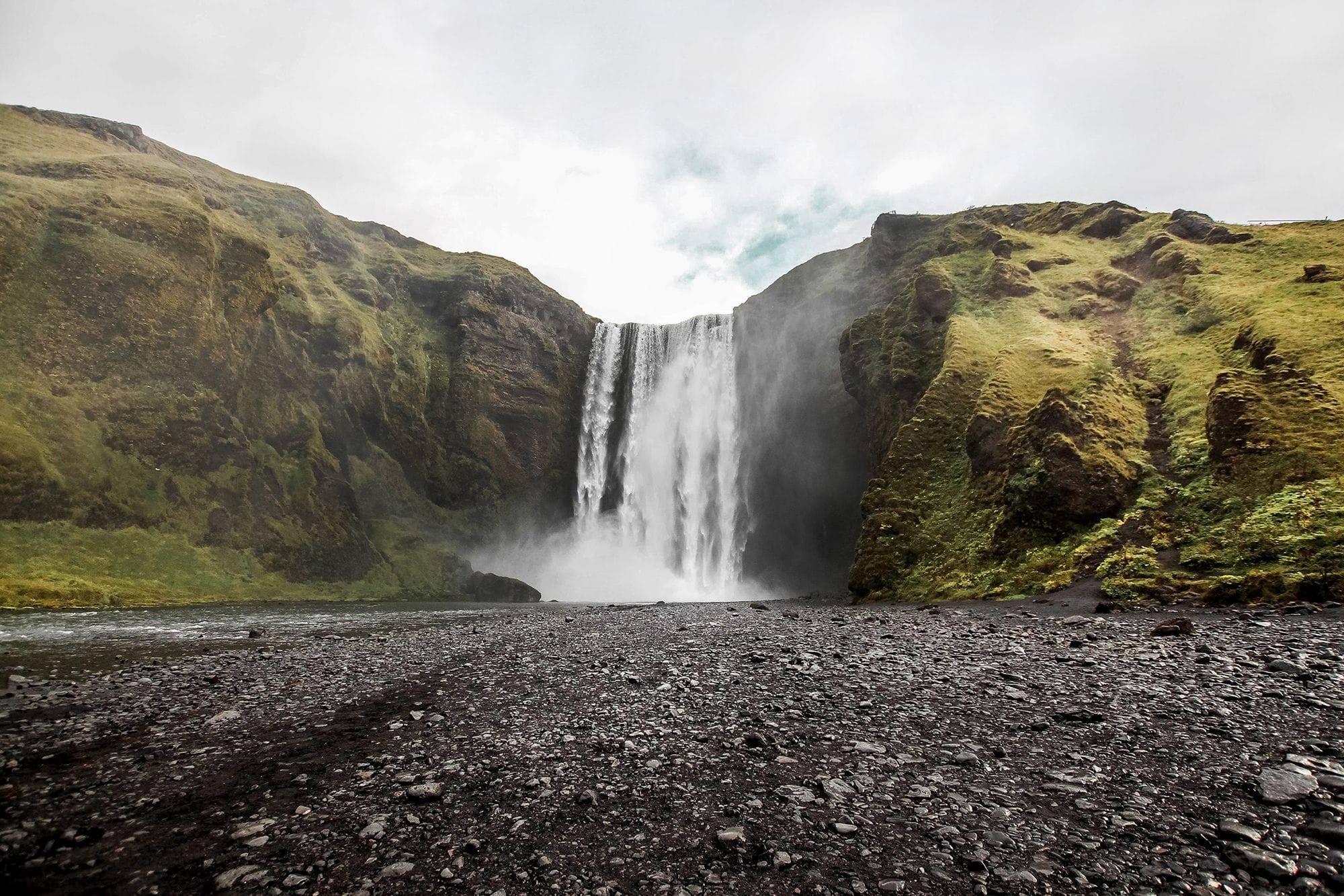 Waterfall with green hills on both sides