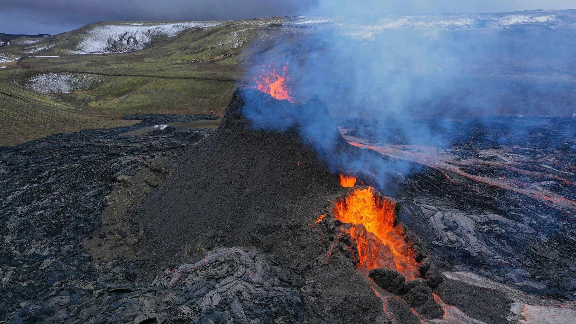 Lava flowing and smoke coming from volcano crater  