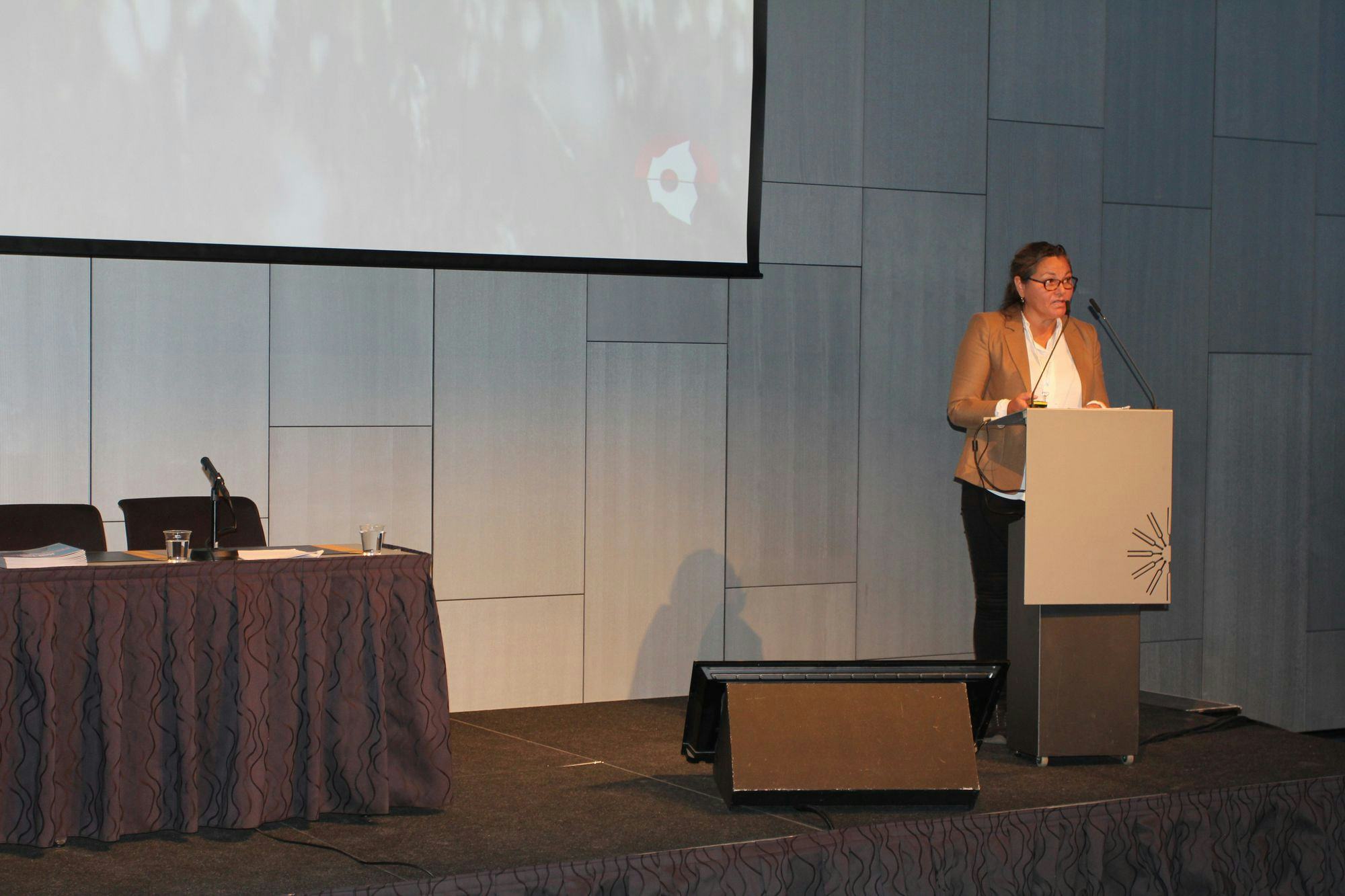 a woman giving speech at a conference