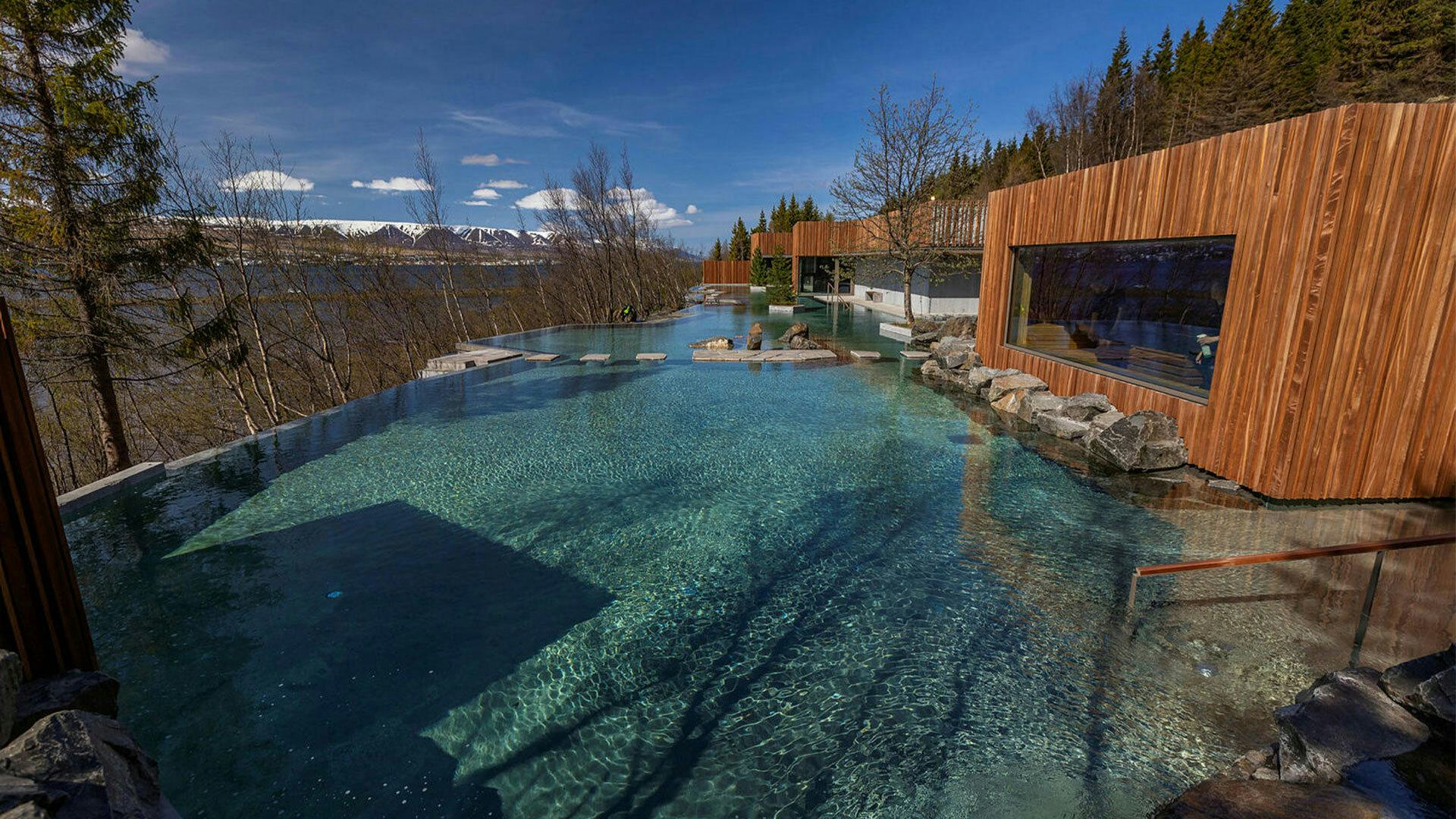 Geothermal spa surrounded by pine trees, overlooking fjords. 