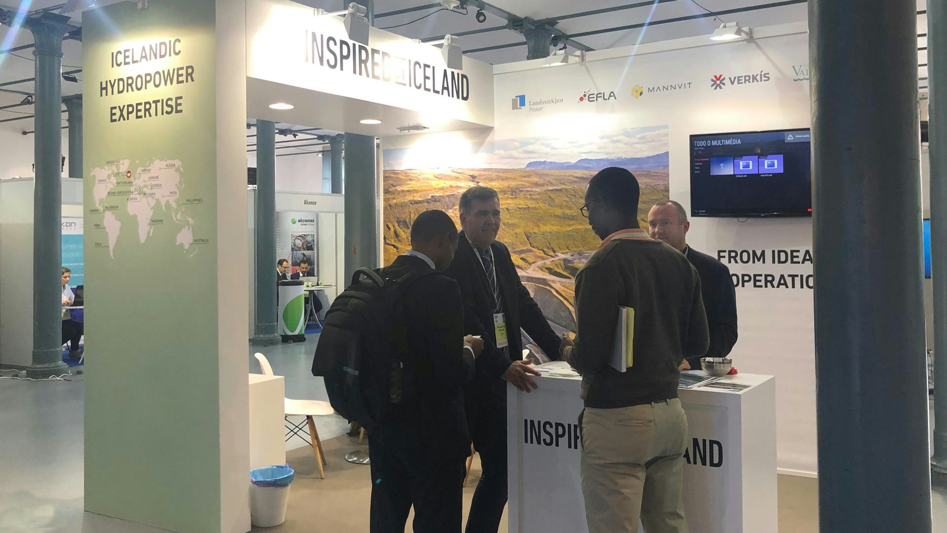 Four men talking to each other at Inspired by Iceland booth 