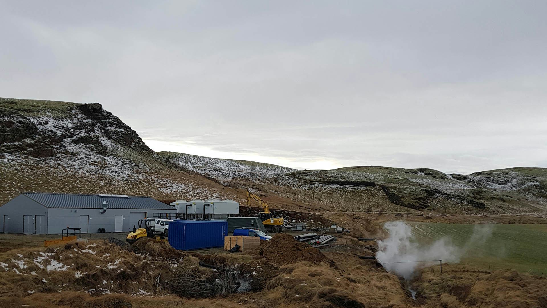 small geothermal powerplant with hill background
