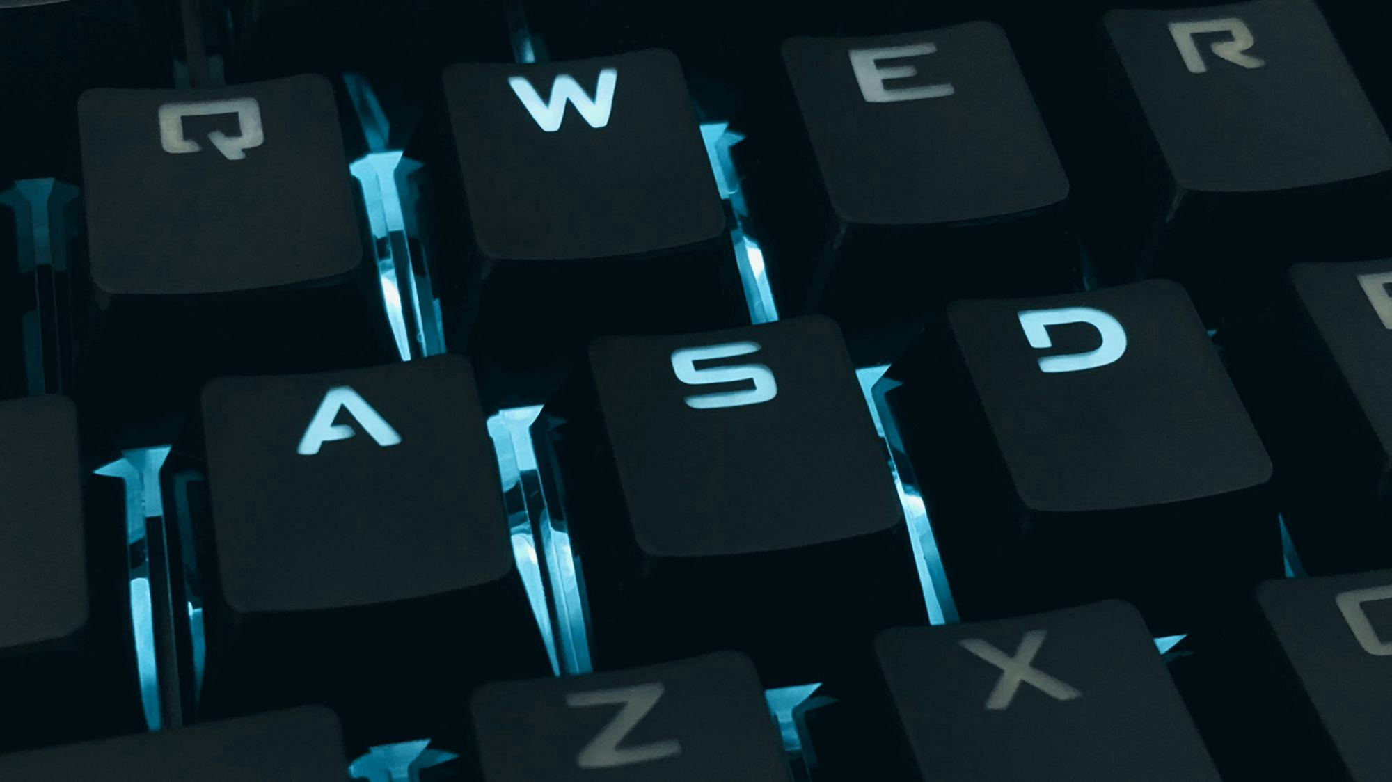 A black computer keypboard with blue lid up letters, you can se A-S-D and W 