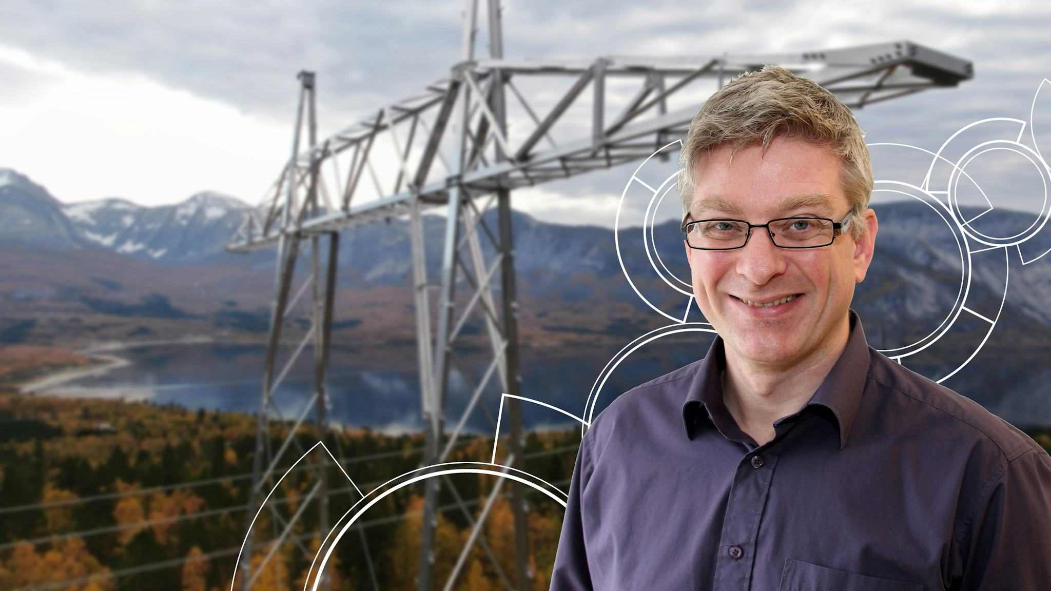 A smiling man with the background of transmission tower