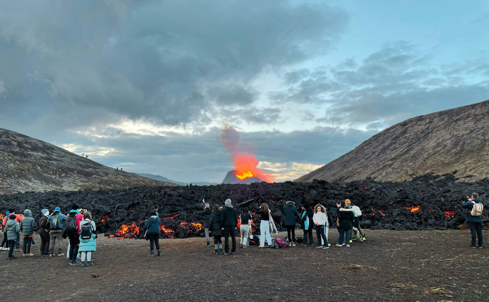 People standing around a volcano eruption